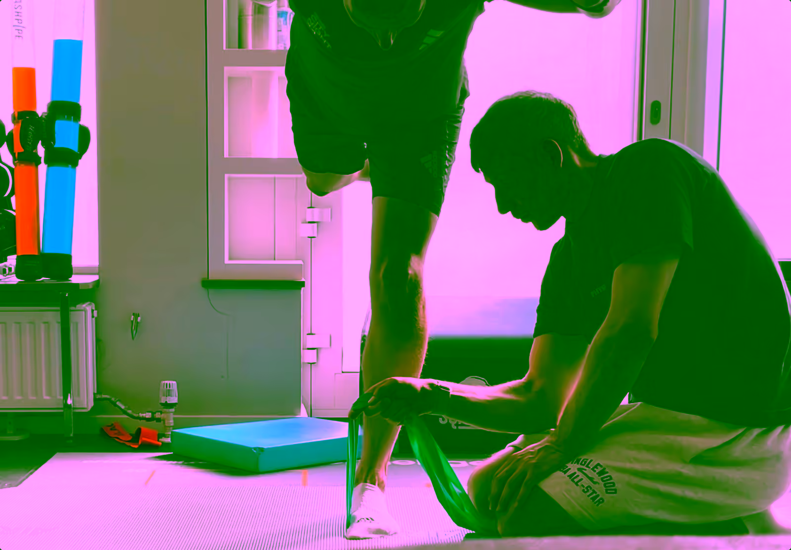 Physiotherapeut kräftigt mit einem Übungsband die Fußmuskulatur im Einbeinstand – Training bei Shin Splints in der Praxis physio&du